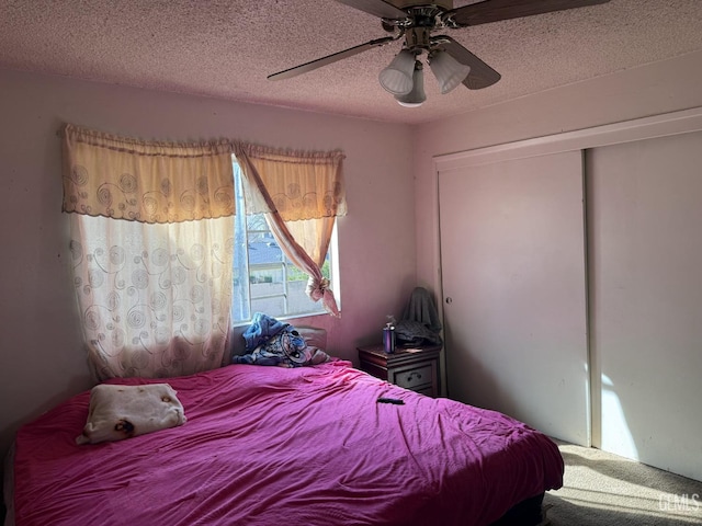 bedroom with ceiling fan, a closet, and a textured ceiling