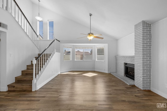 unfurnished living room with wood finished floors, visible vents, a ceiling fan, a fireplace, and stairs