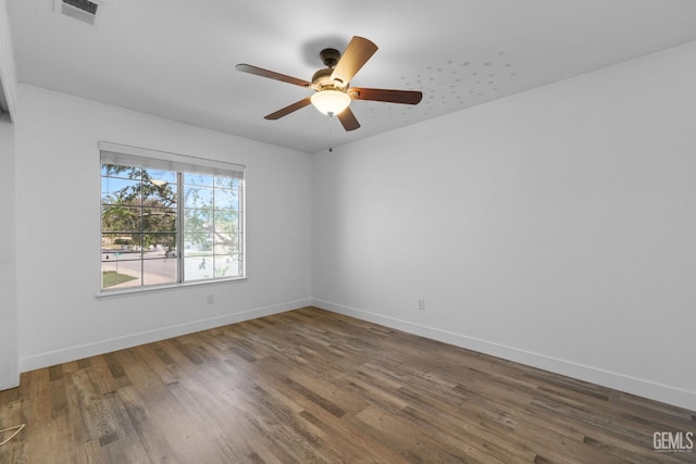 unfurnished room featuring visible vents, ceiling fan, baseboards, and wood finished floors