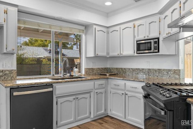 kitchen with a sink, under cabinet range hood, stainless steel microwave, dishwashing machine, and black range with gas stovetop