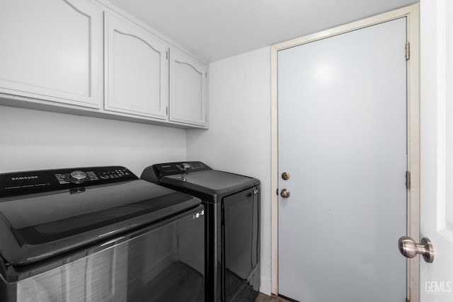 clothes washing area featuring washer and dryer and cabinet space