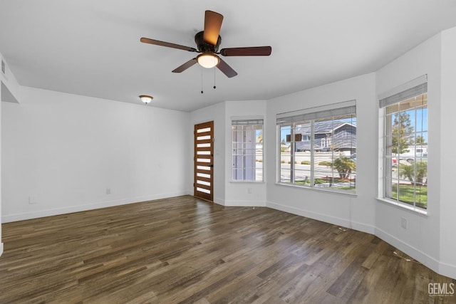 empty room featuring baseboards, wood finished floors, and a ceiling fan