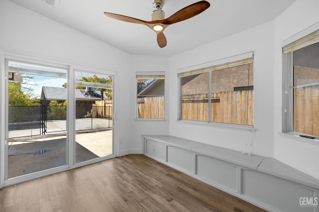 unfurnished sunroom with ceiling fan