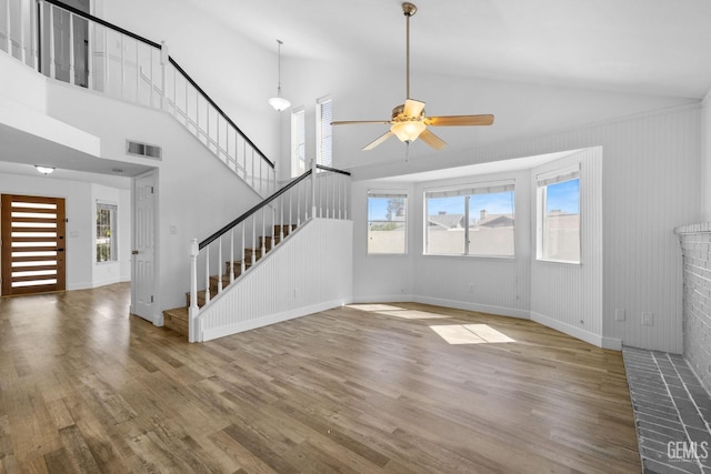 unfurnished living room featuring visible vents, baseboards, stairs, wood finished floors, and a ceiling fan