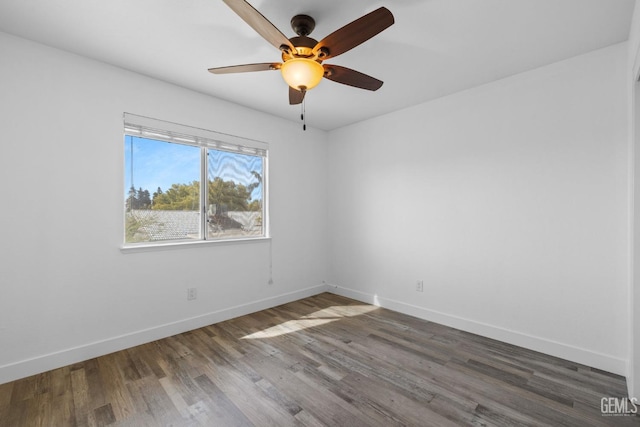 empty room featuring ceiling fan, baseboards, and wood finished floors