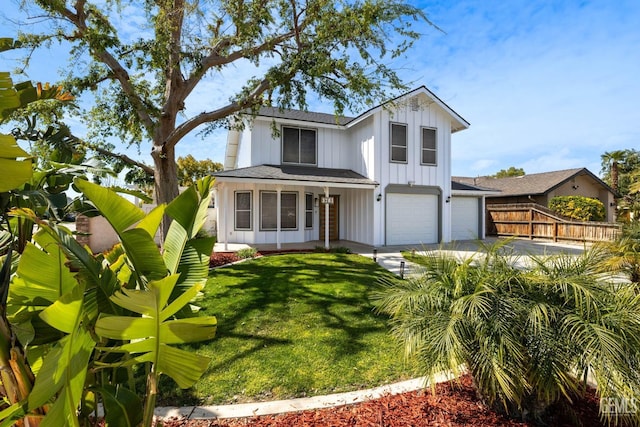 view of front of property featuring a front yard, fence, driveway, a garage, and board and batten siding