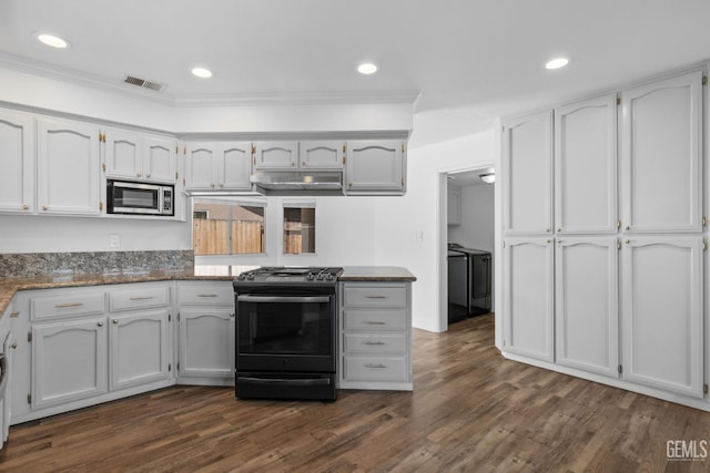 kitchen featuring gas stove, visible vents, separate washer and dryer, dark wood-style flooring, and stainless steel microwave