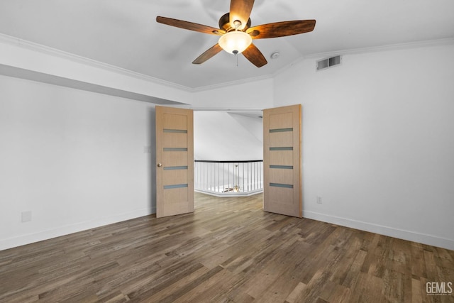 spare room with visible vents, crown molding, baseboards, and wood finished floors