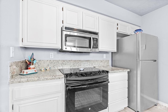 kitchen featuring stainless steel appliances and white cabinetry