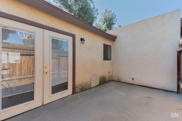 property entrance with french doors, a patio area, and stucco siding