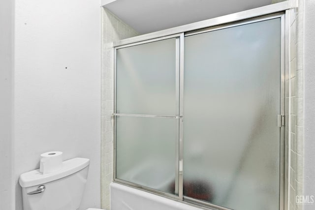 full bath with toilet and bath / shower combo with glass door