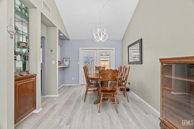 dining space featuring vaulted ceiling, baseboards, visible vents, and light wood-style floors