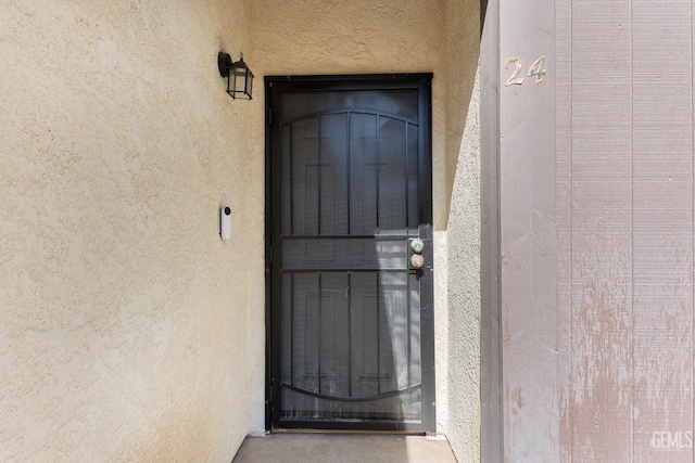 entrance to property featuring stucco siding