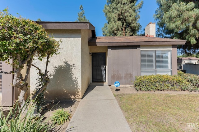 entrance to property featuring stucco siding