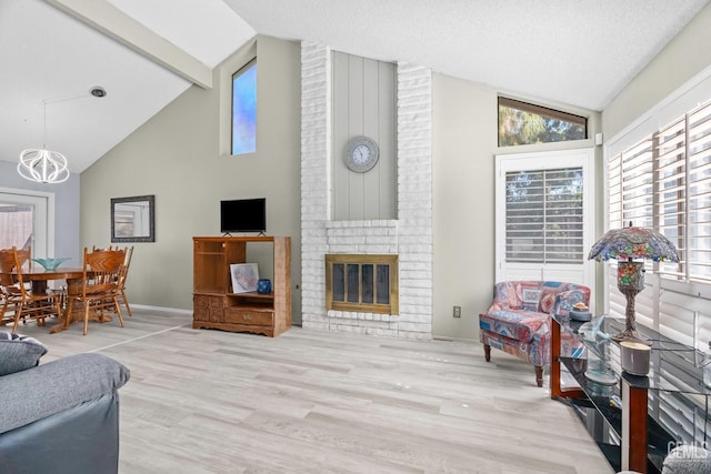 living room with a fireplace, a textured ceiling, wood finished floors, beamed ceiling, and baseboards