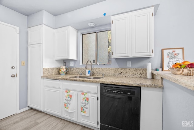 kitchen featuring black dishwasher, light wood-style flooring, light stone counters, white cabinetry, and a sink