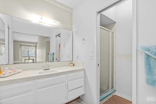 full bath with a shower stall, vanity, and baseboards