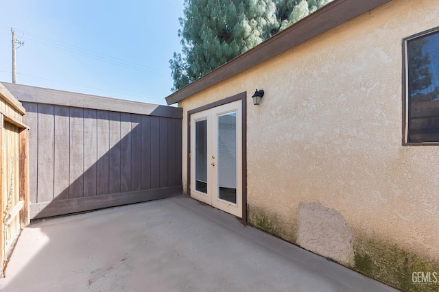 exterior space with a patio area, fence, stucco siding, and french doors