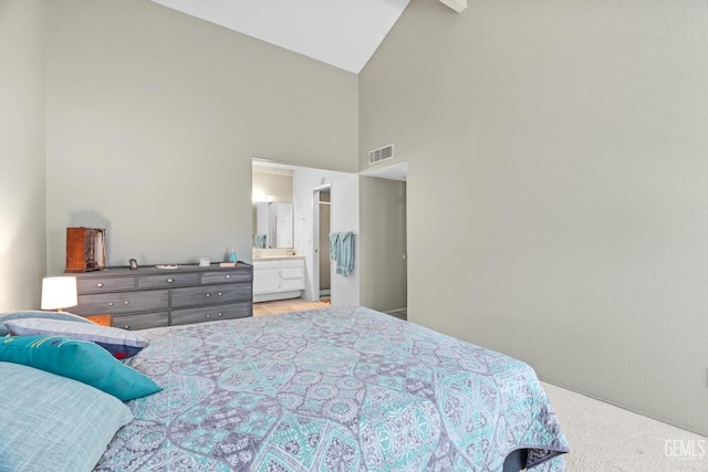 bedroom featuring high vaulted ceiling, connected bathroom, and visible vents