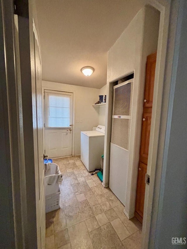 clothes washing area featuring laundry area, stone finish flooring, and washer / dryer