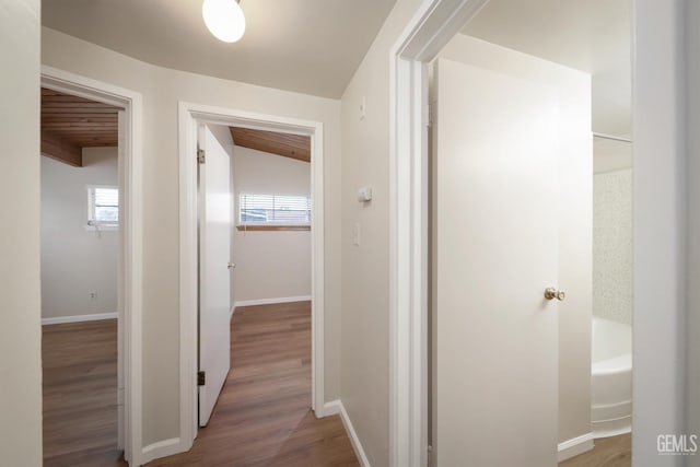 hall featuring wood ceiling, beam ceiling, baseboards, and wood finished floors