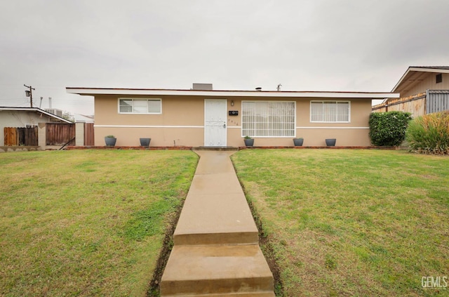 ranch-style house featuring fence, a front lawn, and stucco siding