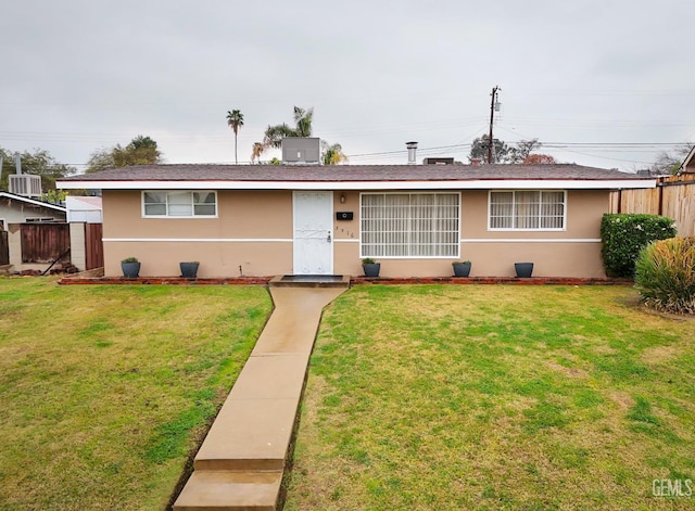 ranch-style house with central AC, fence, a front lawn, and stucco siding