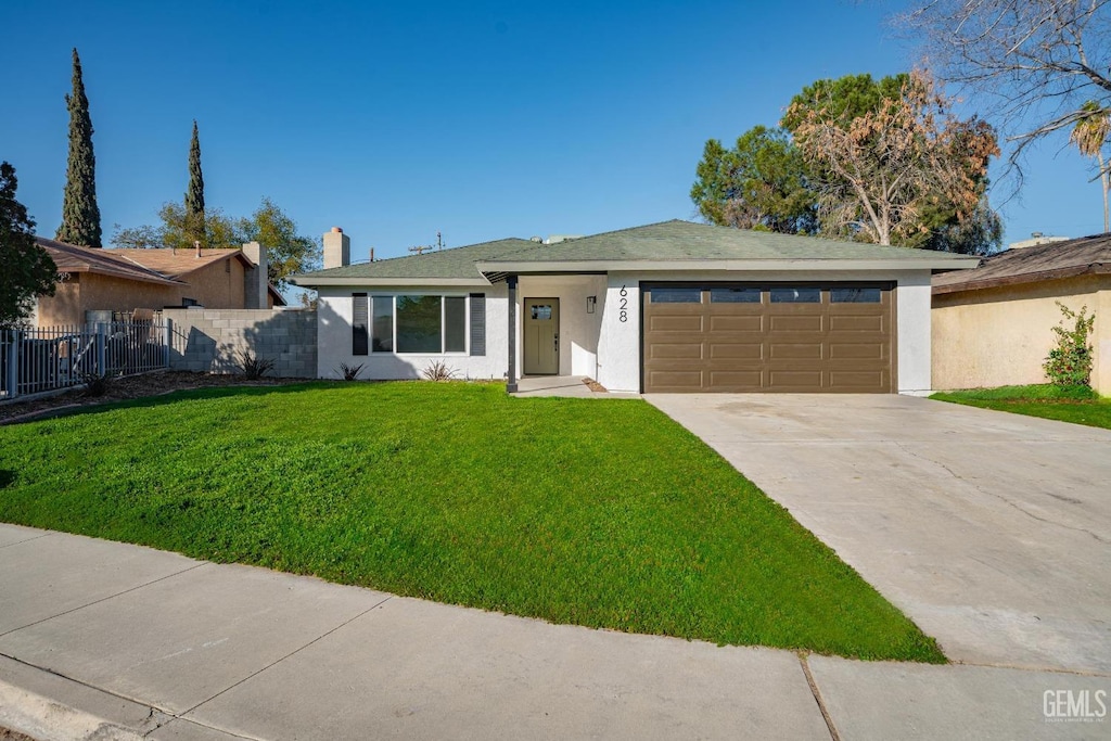 view of front of home with a front yard and a garage