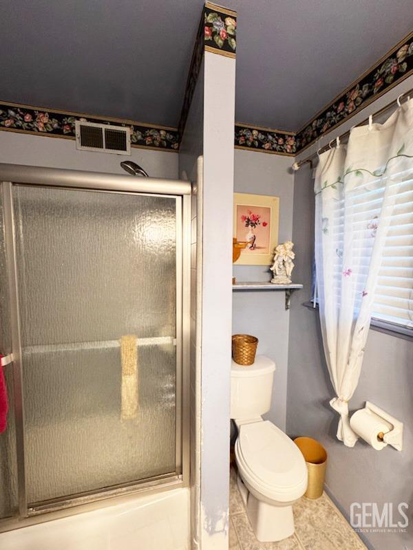 1041 Golden Gate Ave, Dos Palos, CA 93620 - bathroom with visible vents, tile patterned floors, toilet, and a shower stall