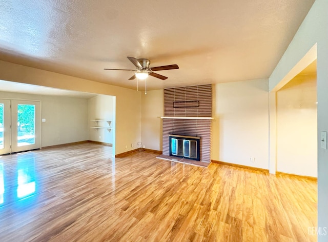 1041 Golden Gate Ave, Dos Palos, CA 93620 - unfurnished living room featuring light wood-style flooring, ceiling fan, and a brick fireplace