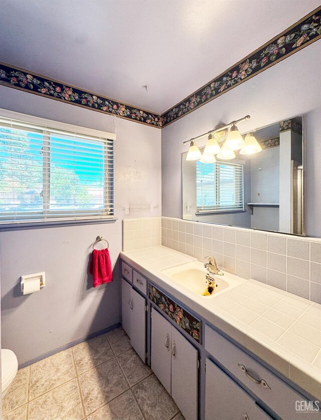 1041 Golden Gate Ave, Dos Palos, CA 93620 - bathroom with plenty of natural light, vanity, tasteful backsplash, and tile patterned floors