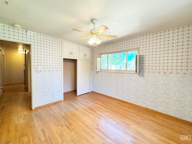1041 Golden Gate Ave, Dos Palos, CA 93620 - unfurnished bedroom featuring wallpapered walls, light wood-style flooring, a closet, and a ceiling fan