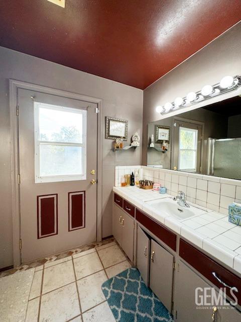 1041 Golden Gate Ave, Dos Palos, CA 93620 - bathroom featuring tile patterned floors, decorative backsplash, and vanity