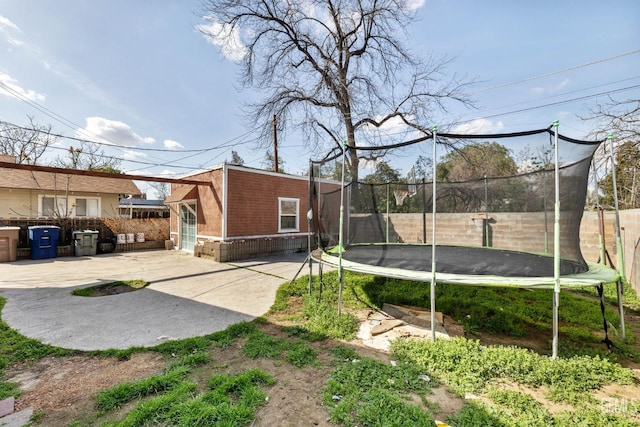 2122 Palm St, Bakersfield, CA 93304 - view of yard with fence private yard, a trampoline, and a patio area