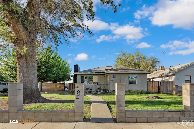 bungalow-style home featuring a fenced front yard, a chimney, a front lawn, roof mounted solar panels, and stucco siding