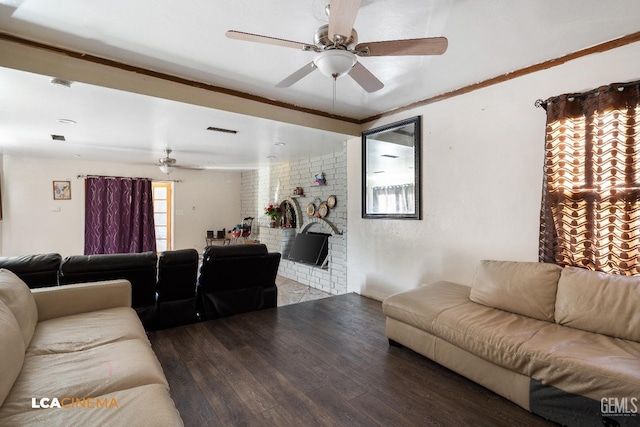 living room featuring a brick fireplace, wood finished floors, visible vents, and a ceiling fan