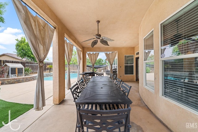 view of patio / terrace with outdoor dining space, a fenced in pool, a fenced backyard, and a ceiling fan