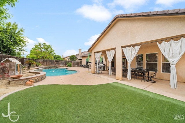 view of swimming pool featuring a lawn, a fenced backyard, a fenced in pool, and a patio