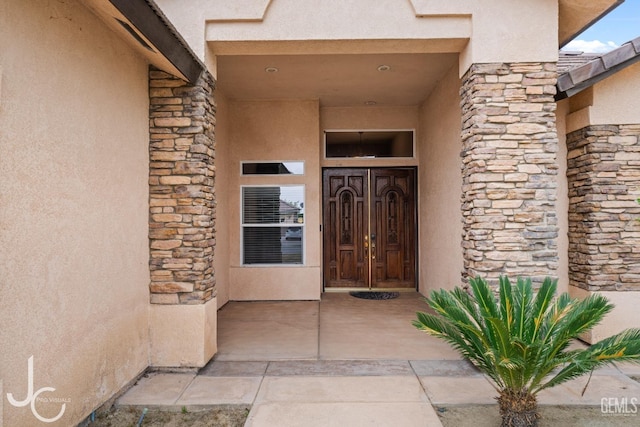 entrance to property featuring stucco siding and stone siding