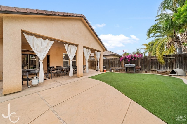view of yard with a fenced backyard, a patio, and outdoor dining area