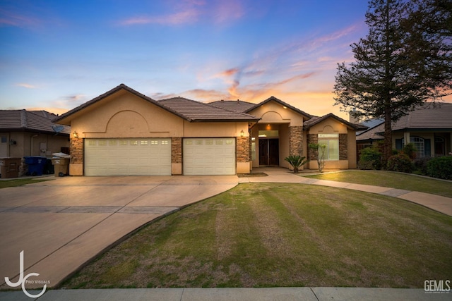 ranch-style house featuring a yard, stucco siding, concrete driveway, a tile roof, and a garage