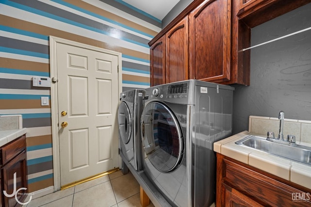 clothes washing area with separate washer and dryer, cabinet space, a sink, and light tile patterned floors