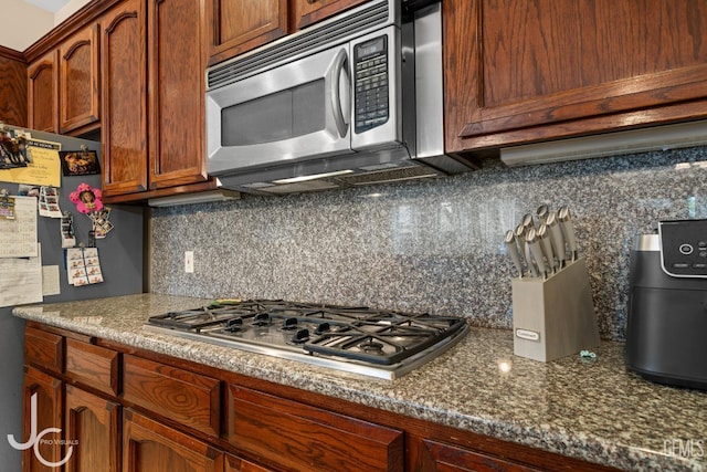 kitchen with appliances with stainless steel finishes and tasteful backsplash