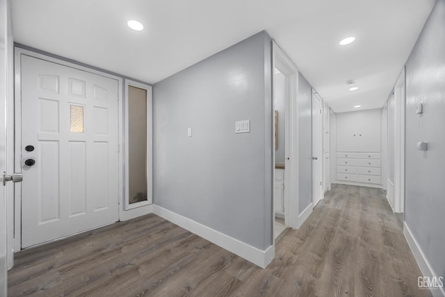 hallway with baseboards, wood finished floors, and recessed lighting