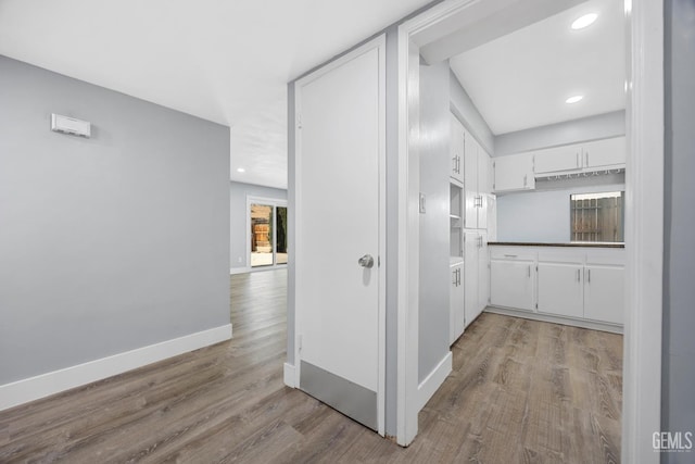 corridor featuring recessed lighting, wood finished floors, and baseboards