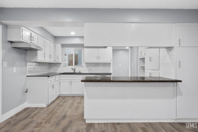 kitchen featuring dark stone countertops, white cabinets, and light wood finished floors