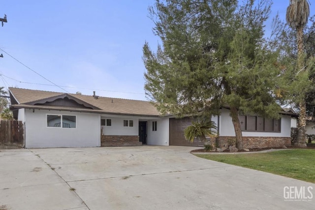 ranch-style house featuring a garage, concrete driveway, brick siding, and stucco siding