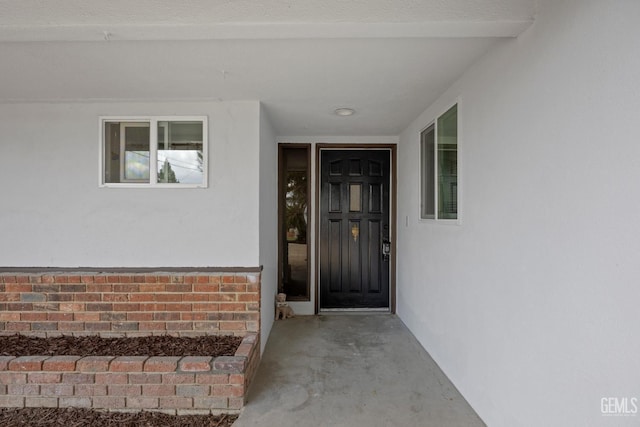 entrance to property with brick siding and stucco siding