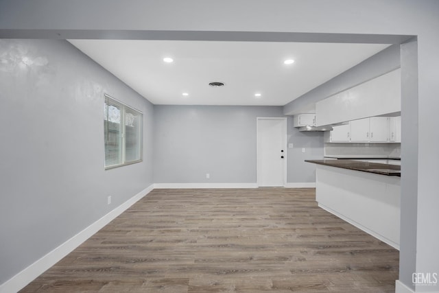 interior space with visible vents, baseboards, wood finished floors, and recessed lighting