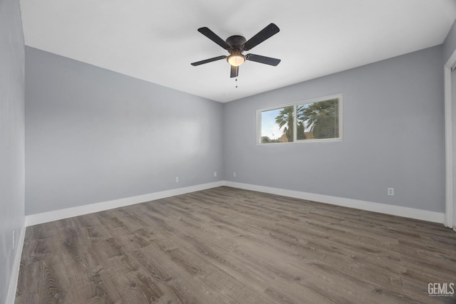 unfurnished room featuring ceiling fan, baseboards, and wood finished floors